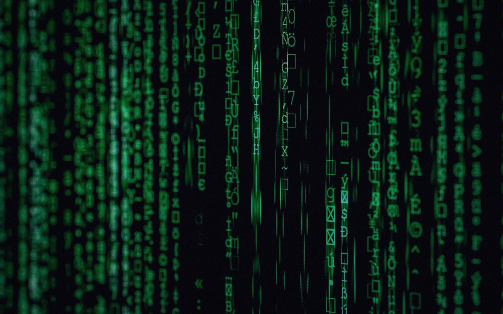 Green cascading digital characters resembling computer code on a black background