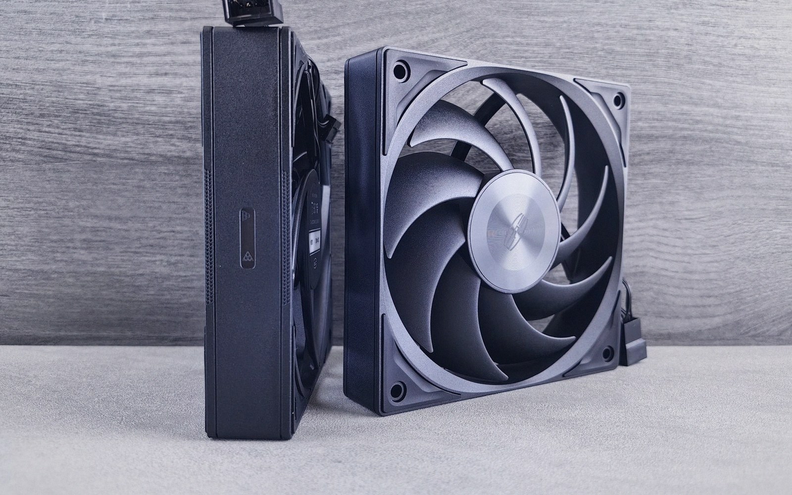 Two computer case fans stand upright, one shown edge-on and one face-on