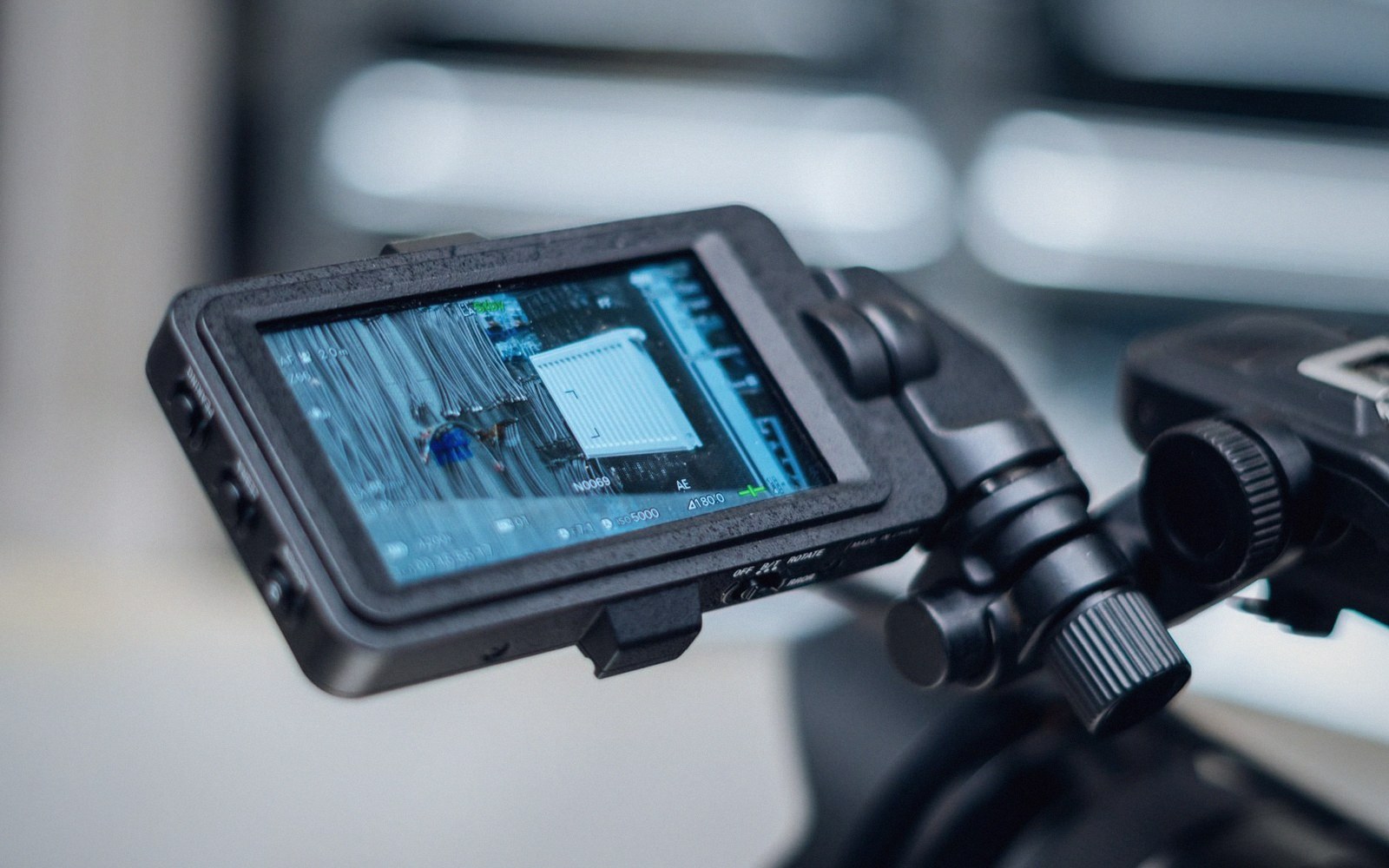 Camera monitor mounted on a rig displaying live footage with exposure data overlays