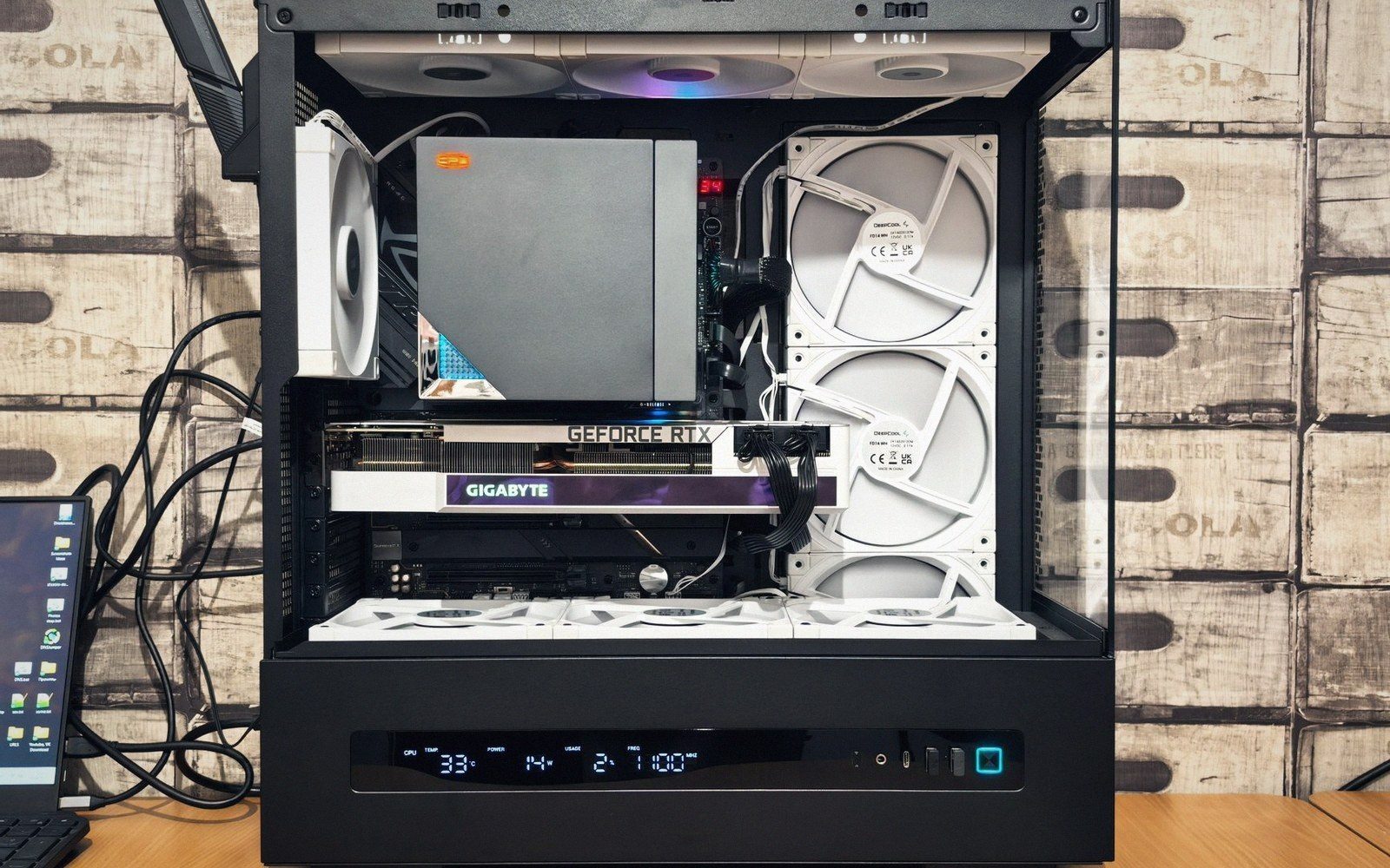 A tower on its side, panel off, graphics card half out of the slot
