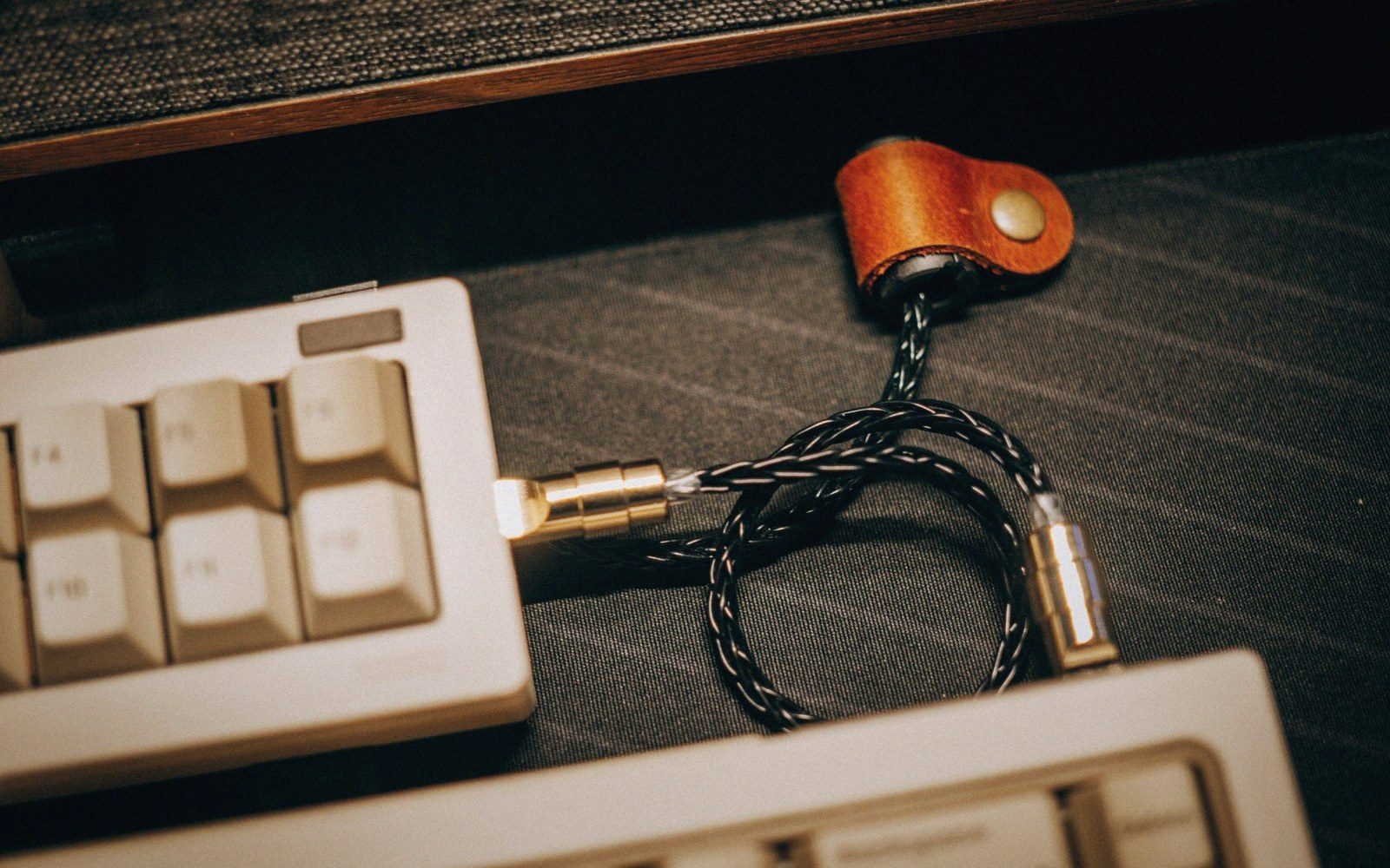 A mechanical keyboard pushed aside, one cable across it